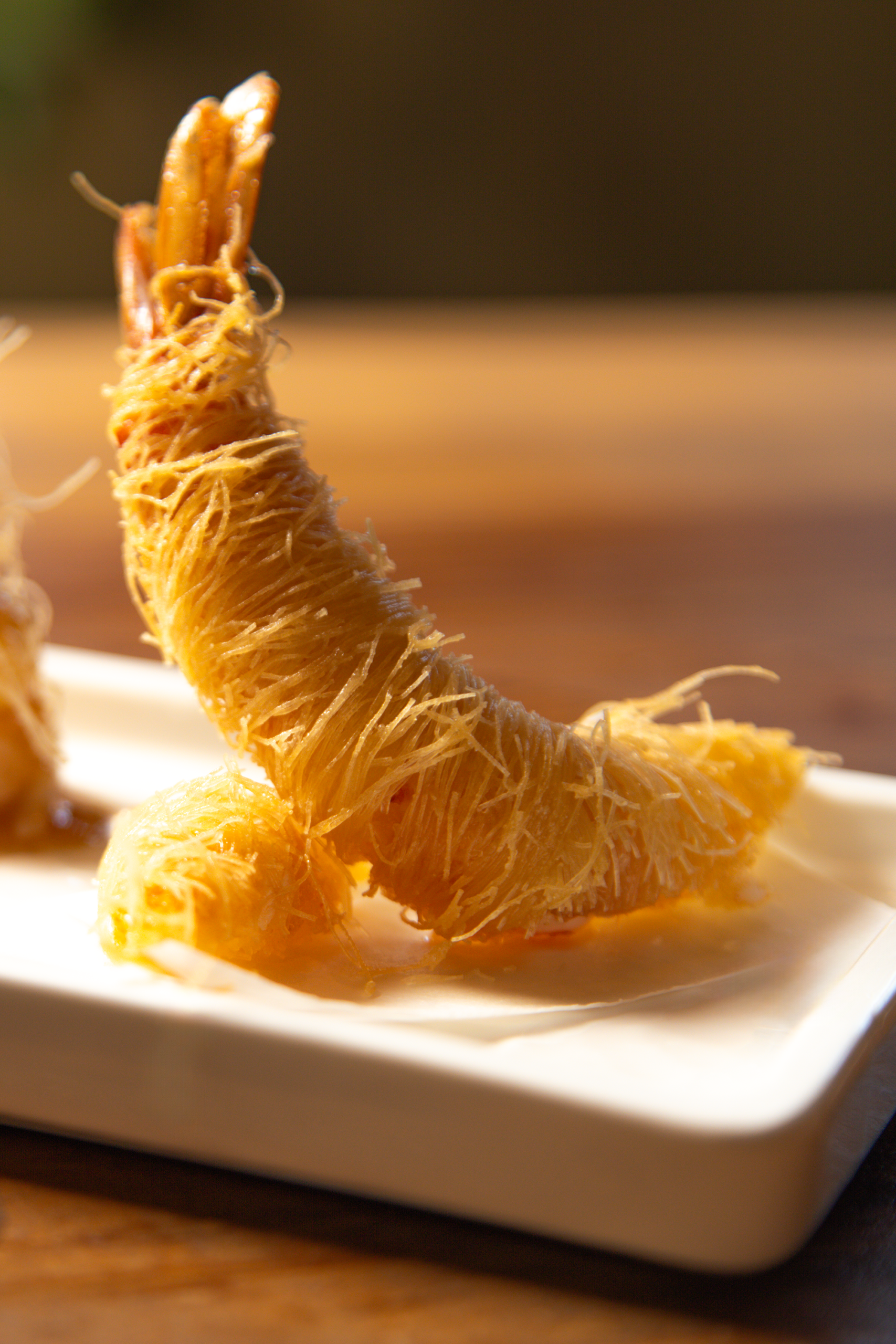 Gambero avvolto in pasta kataifi su piatto bianco