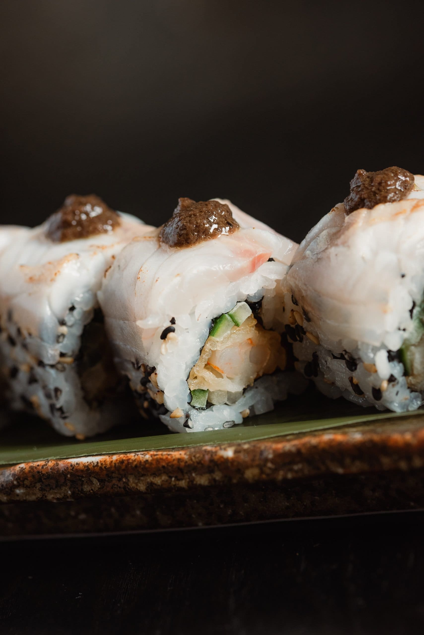 Close-up of elegant sushi topped with olive pâté