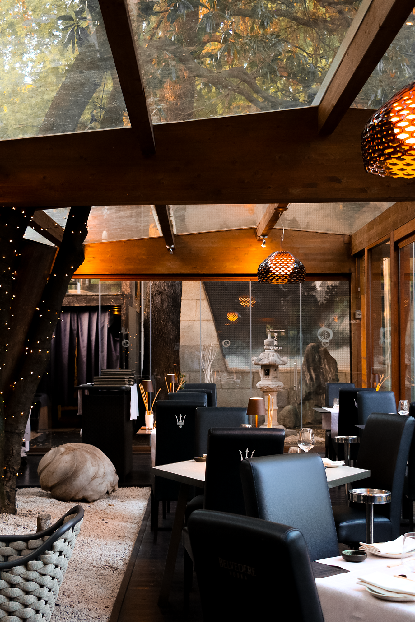 Interno di un ristorante elegante con ampie vetrate e decorazioni moderne.