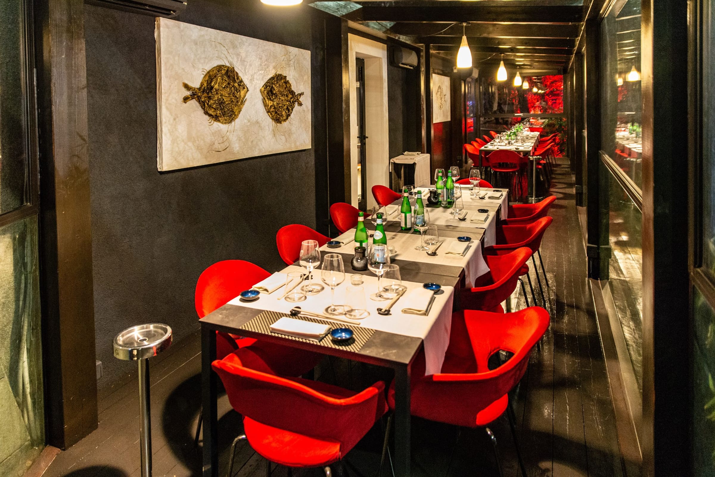 Elegant interior of a Japanese restaurant in Milan with red chairs and set tables