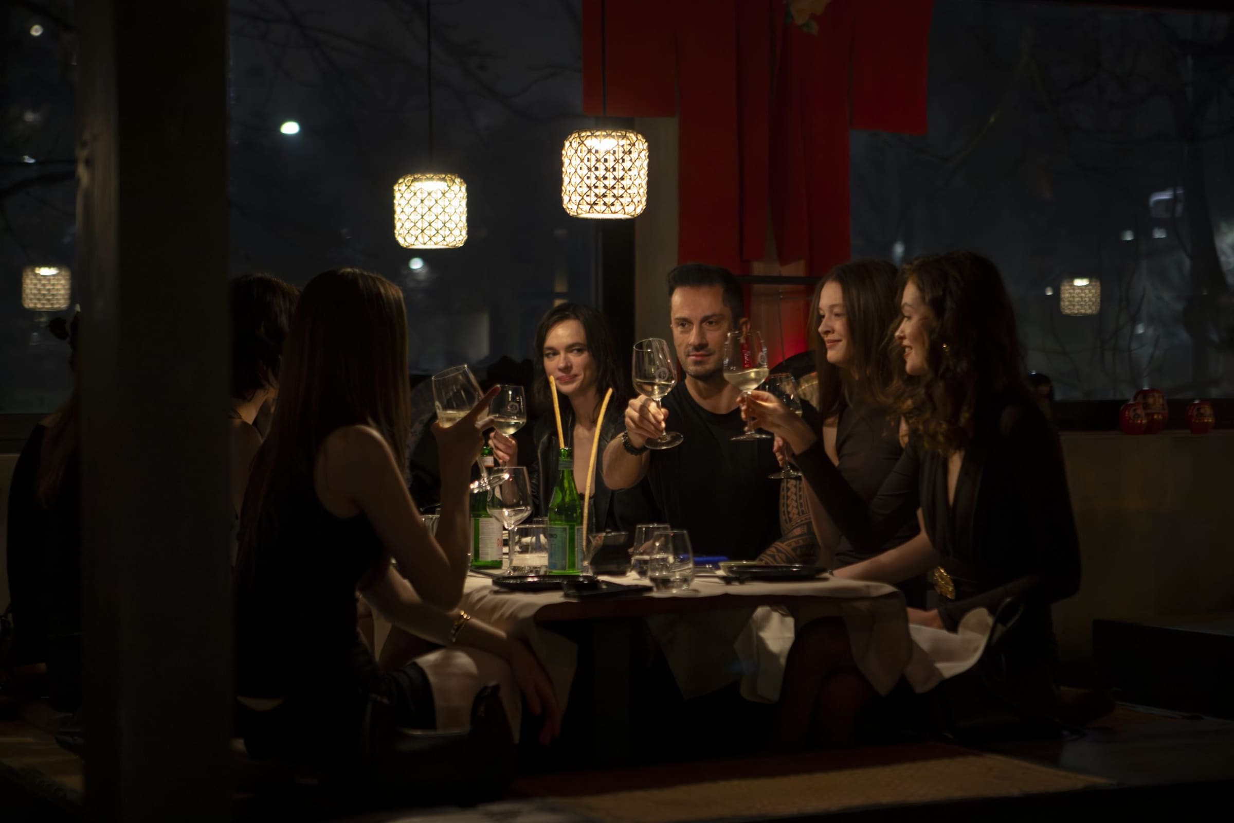 People toasting at dinner in an elegant restaurant.