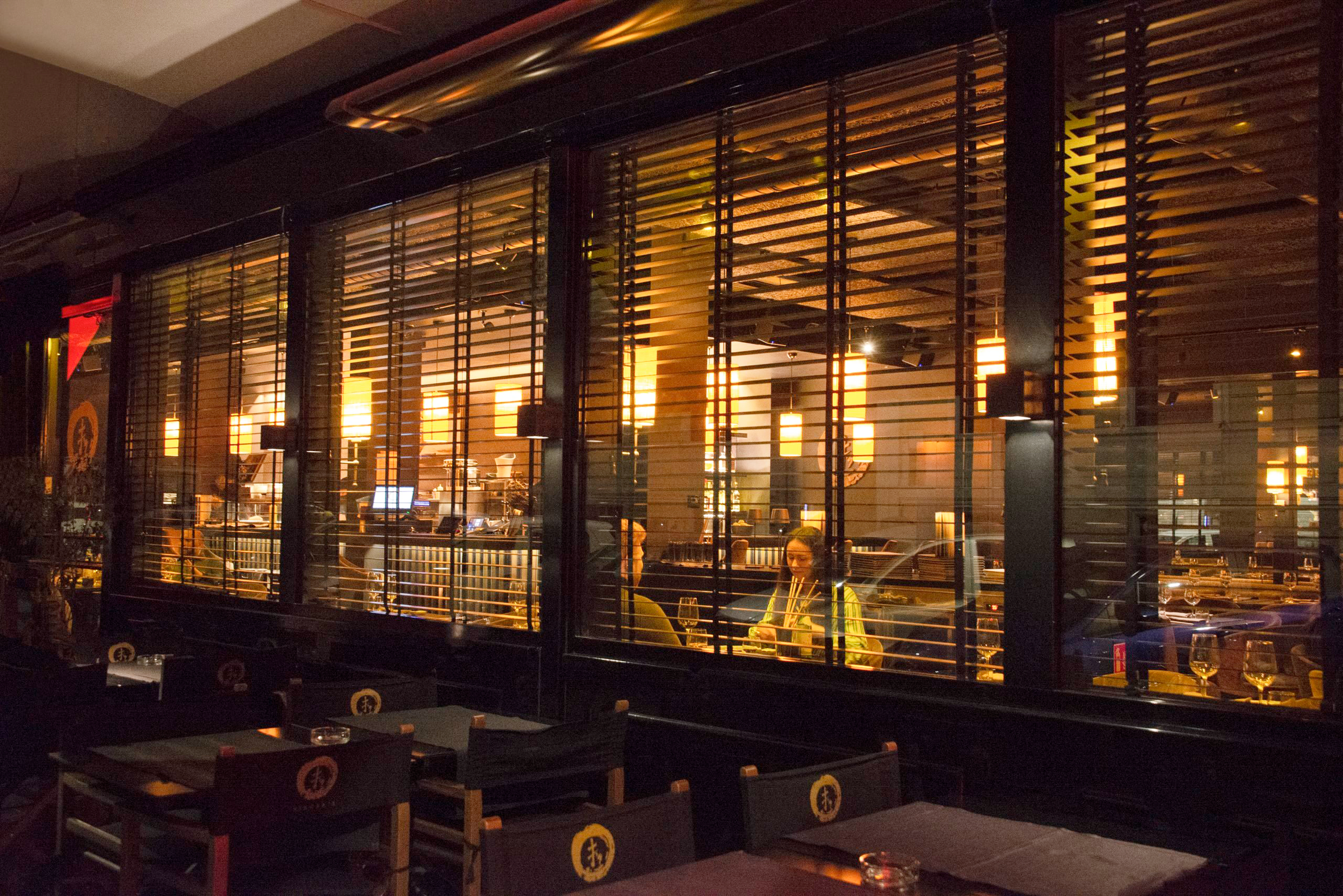 Interno di un ristorante visto dall'esterno con vetrate
